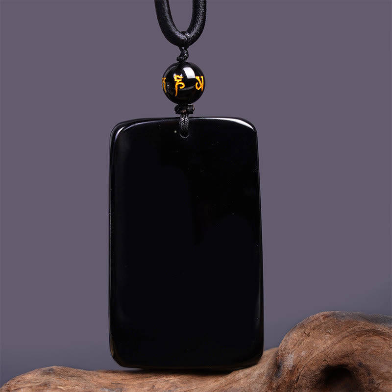 Black Obsidian Dragon Pendant – smooth uncarved rectangular plaque with mantra bead on gray, minimalist