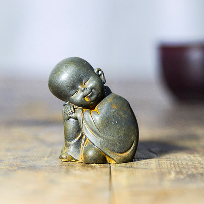 Small Meditating Monk Statue – monk face serene expression close-up, tiny meditation figurine