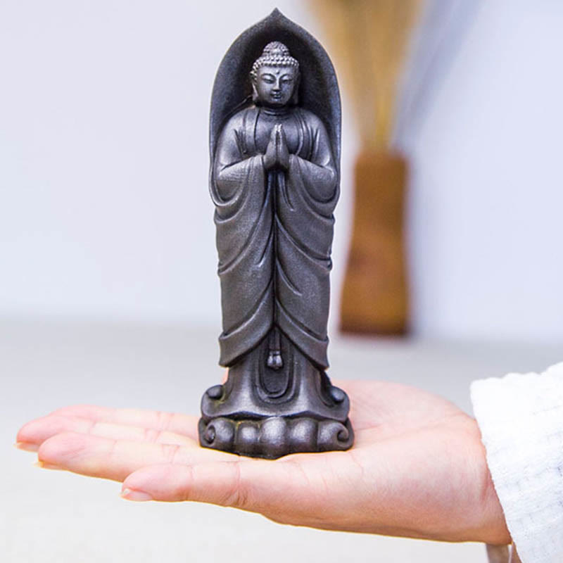 Sakyamuni Namaste Statue – warm spotlight on face emphasizing peaceful contemplative gaze