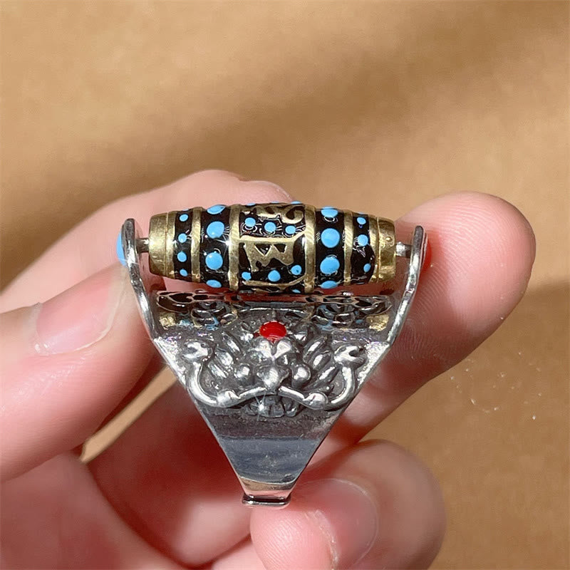 Garuda Dzi Ring – Gold mantra spinner above carved lotus with red coral center held in hand, sacred