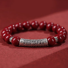 Cinnabar Sterling Silver Six True Words Bracelet – hero shot on red, silver mantra barrel & red beads, blessing bracelet