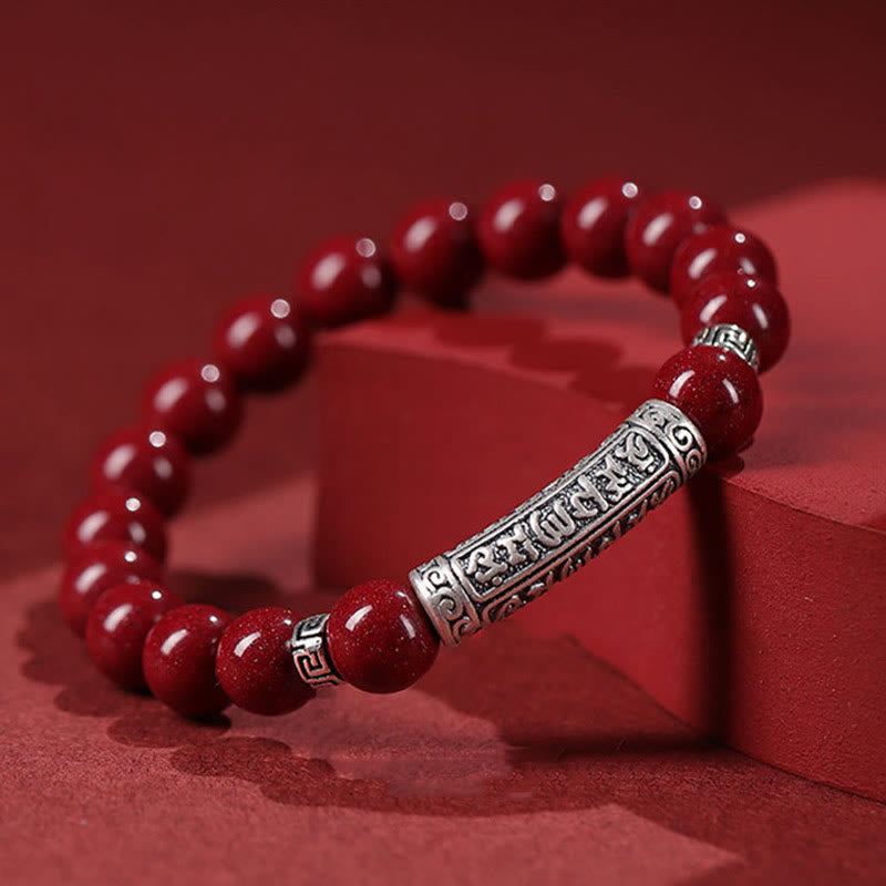 Cinnabar Sterling Silver Six True Words Bracelet – angled on red fabric blocks, silver scrollwork & red beads, calm jewelry
