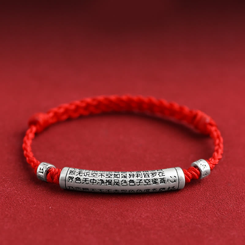 999 Silver Heart Sutra Bracelet – Shallow DOF shot of red cord with engraved silver bead on textured red surface, sutra br...