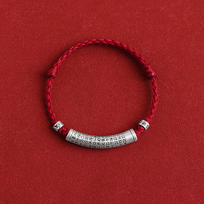 999 Silver Heart Sutra Bracelet – Centered flat lay of red braided bracelet with engraved silver cylinder, amulet jewelry