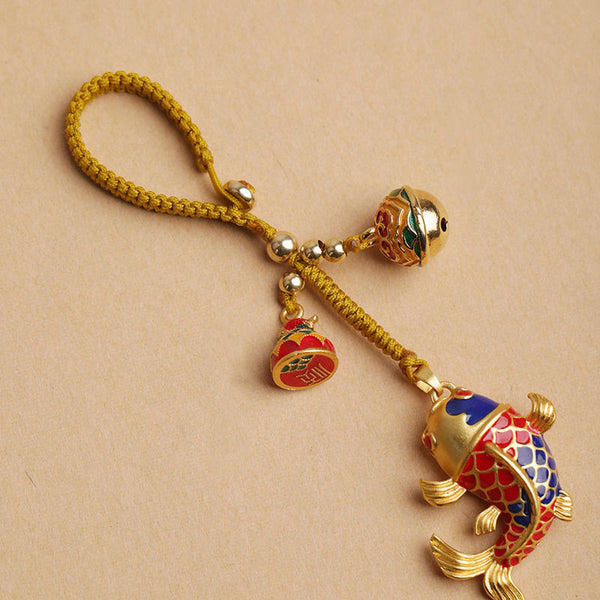 Colorful Koi Fish Hollow Bell Key Chain - top view cloisonne koi with bell, braided golden cord on beige background