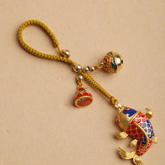 Colorful Koi Fish Hollow Bell Key Chain - top view cloisonne koi with bell, braided golden cord on beige background