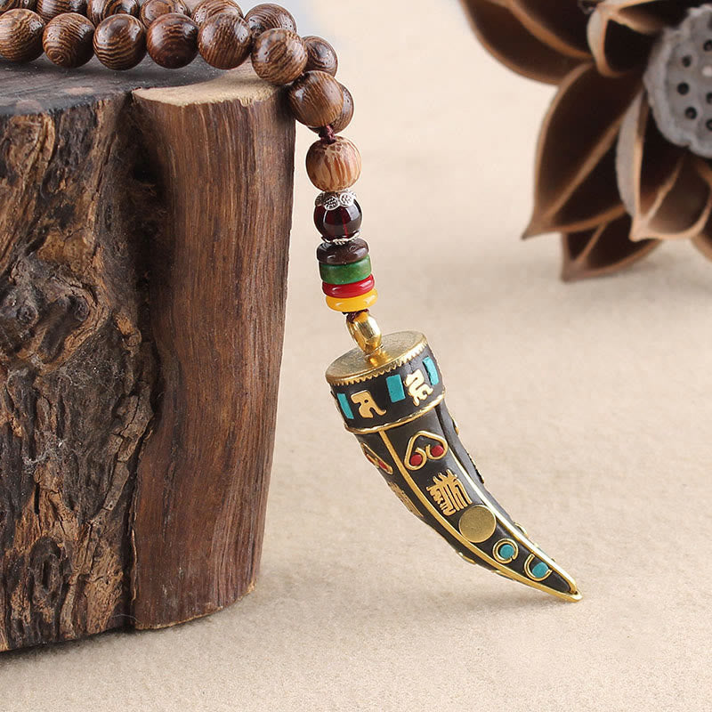Wenge Wood Horn Pendant Necklace – Macro of carved horn pendant with gold mantra, boho necklace