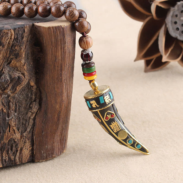 Wenge Wood Horn Pendant Necklace – Macro of carved horn pendant with gold mantra, boho necklace