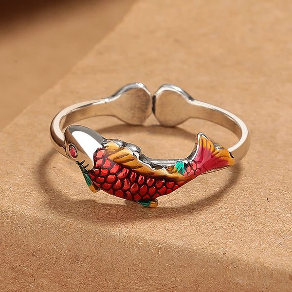 Koi Fish Wealth Prosperity Ring - silver adjustable band with red-orange enamel koi scales and golden fins on kraft paper