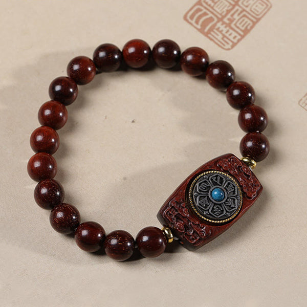 Sandalwood Six True Words Bracelet - Overhead view of carved mantra plaque with turquoise inlay