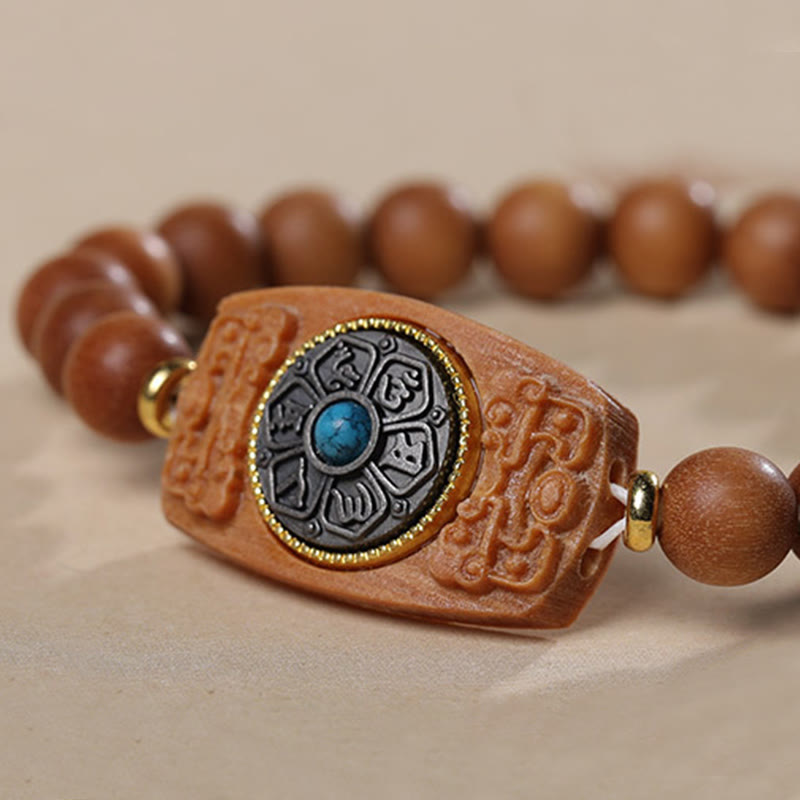 Sandalwood Six True Words Bracelet - Close-up of turquoise inlay on carved wooden centerpiece