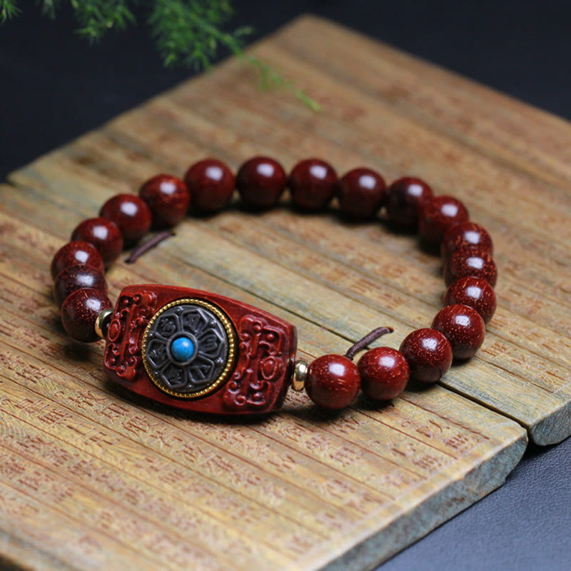 Sandalwood Six True Words Bracelet - Red wood beads with blue stone centerpiece on rustic wood