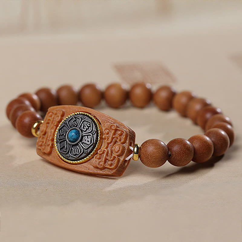 Sandalwood Six True Words Bracelet - Side angle of carved wooden plaque with gold mantra ring