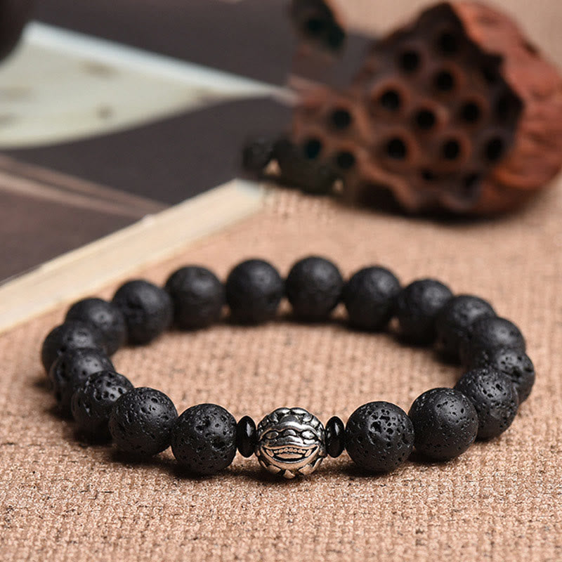 Lava Rock PiXiu Wealth Bracelet with silver bead on burlap, book and lotus pod props, volcanic stone jewelry