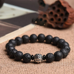 Lava Rock PiXiu Wealth Bracelet with silver bead on burlap, book and lotus pod props, volcanic stone jewelry