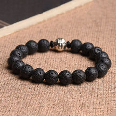Volcanic Lava Stone PiXiu Bracelet with metal bead on burlap fabric, book prop, aromatherapy diffuser jewelry
