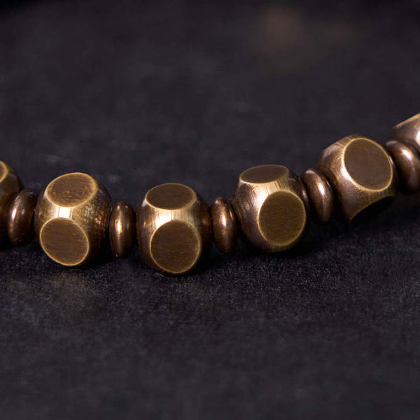 Om Mani Padme Hum Brass Bracelet - Close-up faceted barrel beads with warm bronze patina, handcrafted bracelet