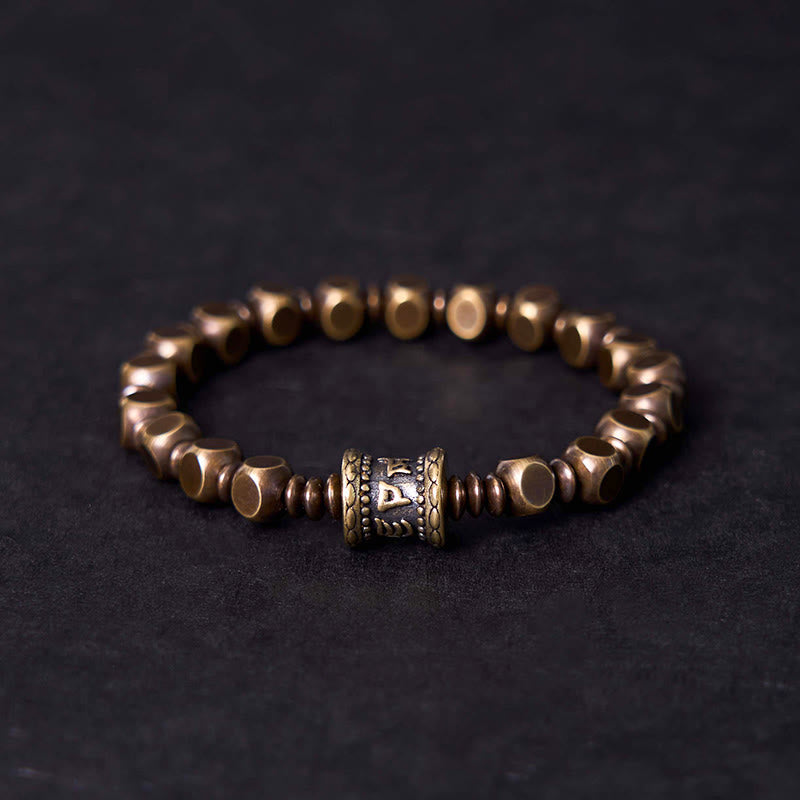 Om Mani Padme Hum Brass Bracelet - Brass hexagonal beads with prayer wheel focal, dark backdrop, men spiritual