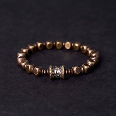 Om Mani Padme Hum Brass Bracelet - Brass hexagonal beads with prayer wheel focal, dark backdrop, men spiritual