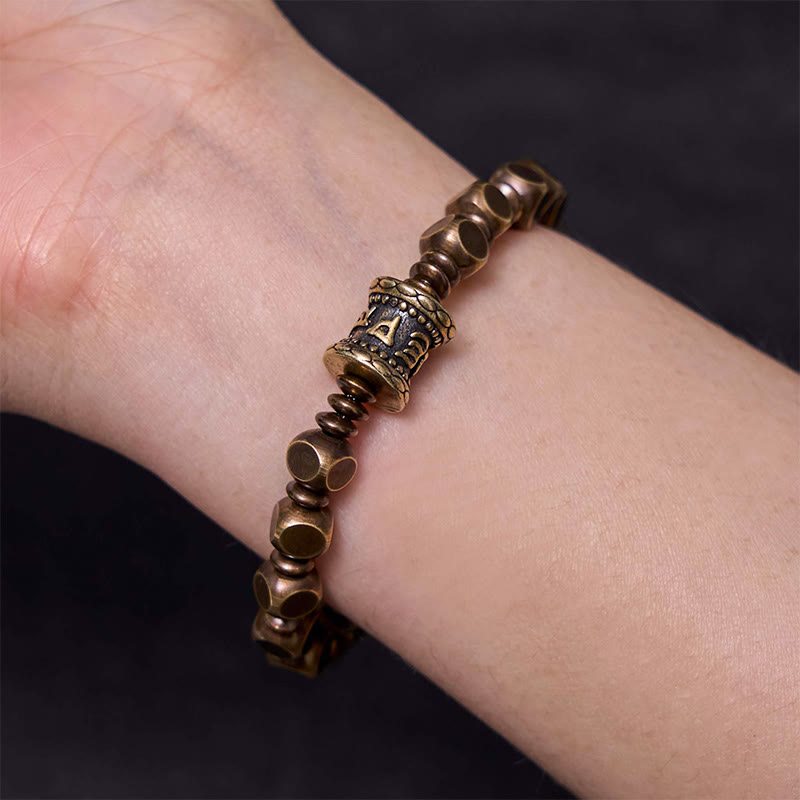 Brass Om Mani Padme Hum Bracelet – on wrist with neutral background showing hexagonal beads and mantra centerpiece, Zen jewelry