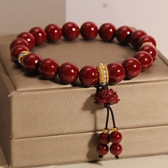 Cinnabar Blessing Bracelet – Carved lotus pendant with red bead strand on gold box, charm bracelet
