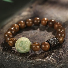 Sandalwood Jade PiXiu Healing Bracelet on weathered stone, green jade carved bead, ebony spacer, zen jewelry