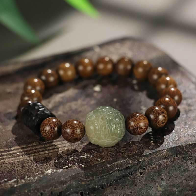 Wood Bead Jade PiXiu Bracelet on rustic stone, carved celadon jade center, dark accent bead, meditation mala