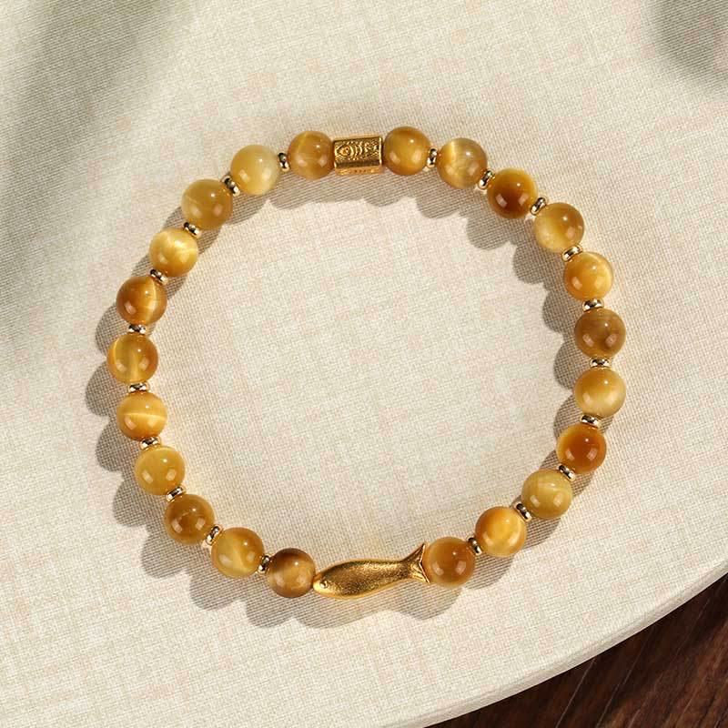 Tiger Eye Koi Fish Courage Bracelet – golden tiger eye beads with gold fish charm on cream linen, flat lay circle