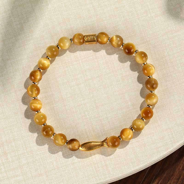 Tiger Eye Koi Fish Courage Bracelet – golden tiger eye beads with gold fish charm on cream linen, flat lay circle