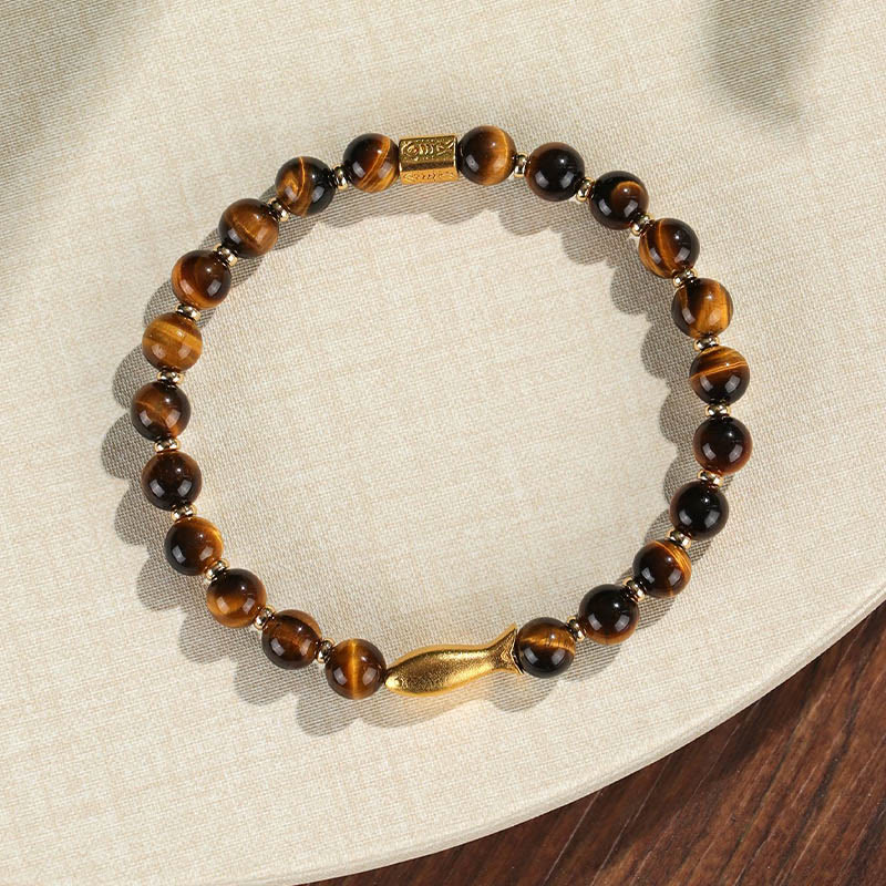 Tiger Eye Koi Fish Courage Bracelet – tiger eye beads with gold fish and barrel charm on linen, flat lay top-down