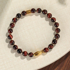 Tiger Eye Koi Fish Courage Bracelet – red tiger eye beads with gold fish charm on linen, flat lay overhead shot