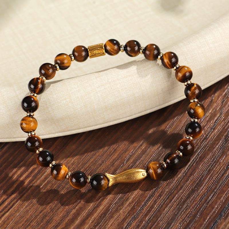 Tiger Eye Koi Fish Courage Bracelet – tiger eye beads with gold fish charm on wood and linen, three-quarter angle