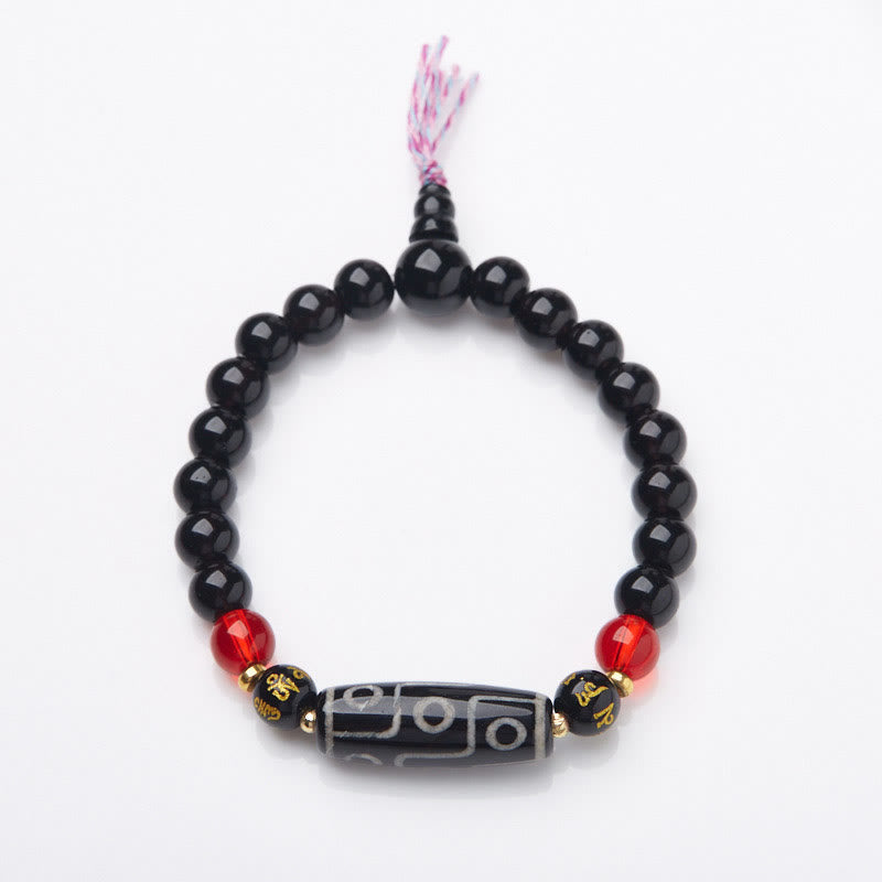 Tibetan Nine-Eye Dzi Bead Black Onyx Bracelet – overhead shot on white, full loop with guru bead & tassel, onyx mala