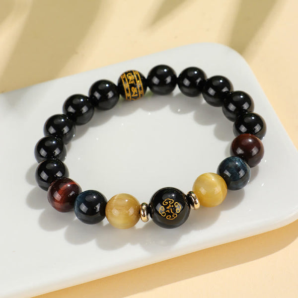Black Onyx Tiger Eye Natal Buddha Bracelet - gold and blue tiger eye on ceramic dish