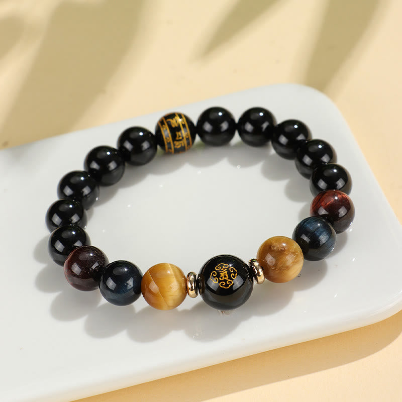Black Onyx Tiger Eye Natal Buddha Bracelet - gold character focal bead on white display