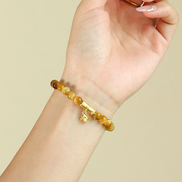 Tiger Eye Fu Bamboo Koi Lotus Bracelet – amber gradient beads with bamboo charm on wrist, three-quarter view
