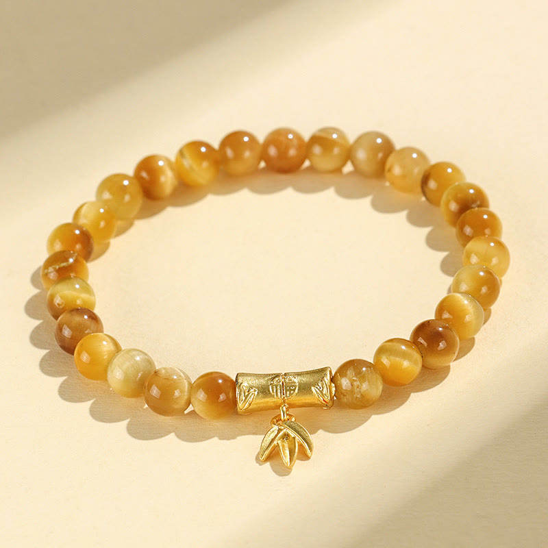 Tiger Eye Fu Bamboo Koi Lotus Bracelet – golden tiger eye beads with gold bamboo and leaf charm on cream, flat lay
