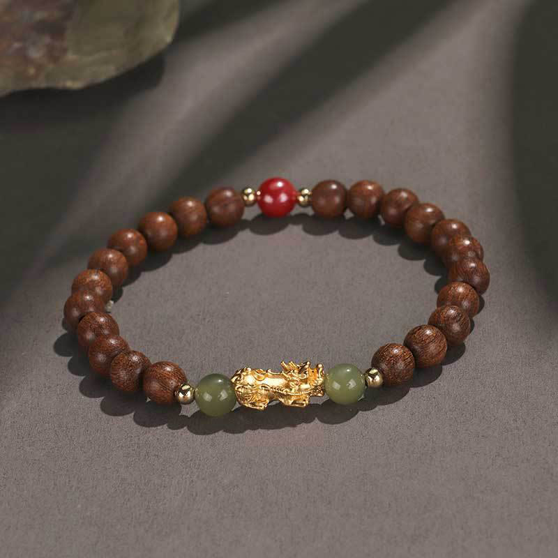 Multi-Wood PiXiu Bracelet – Dark brown wood beads with gold PiXiu, green jade and red bead on gray background