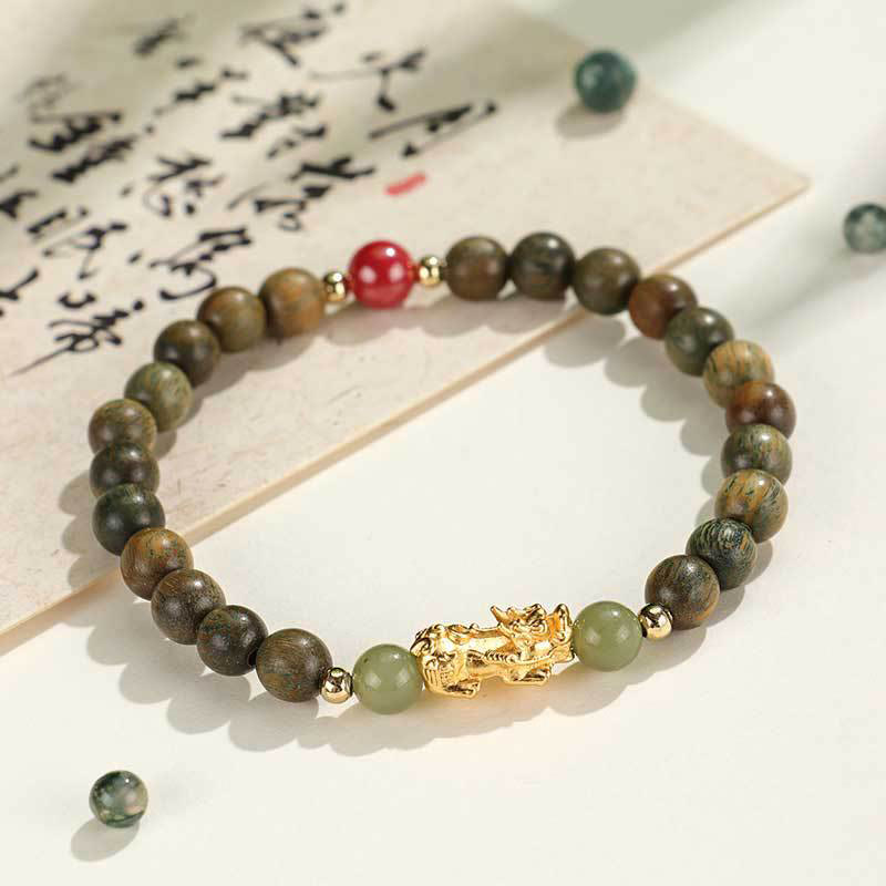 Multi-Wood PiXiu Bracelet – Green sandalwood beads with gold PiXiu and jade on white calligraphy background