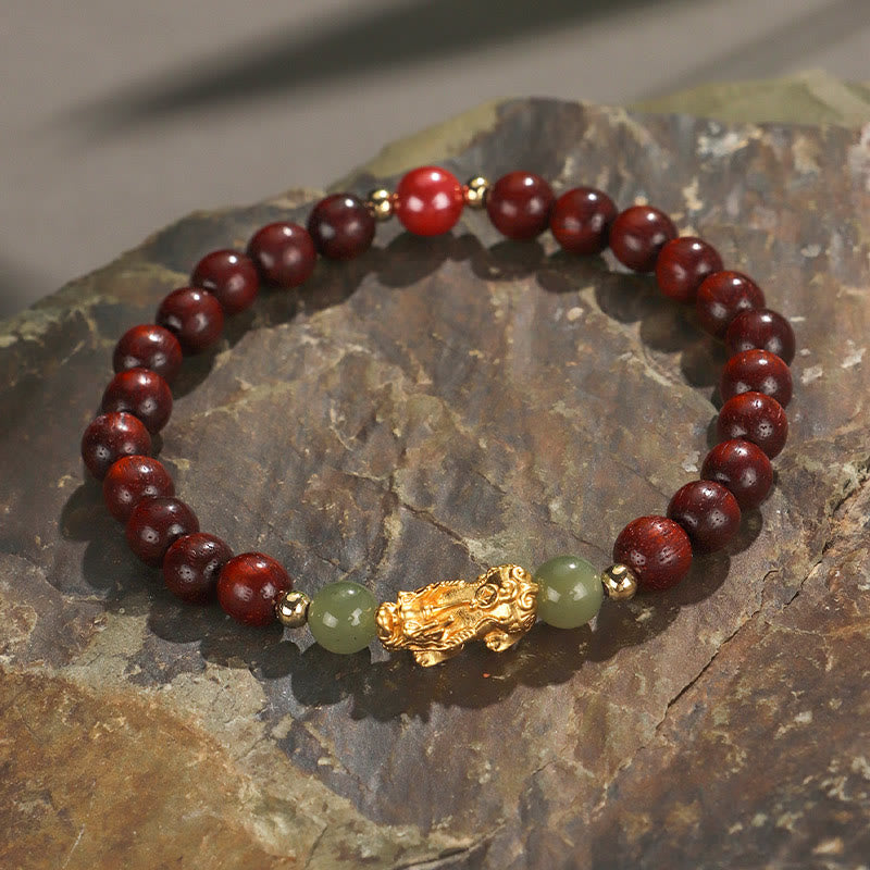 Multi-Wood PiXiu Bracelet – Deep red wood beads with gold PiXiu, green jade and red cinnabar on natural rock