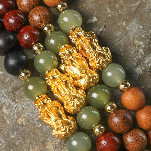 Multi-Wood PiXiu Bracelet – Close-up stack of multiple wood bracelets with gold PiXiu and green jade beads