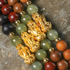 Multi-Wood PiXiu Bracelet – Close-up stack of multiple wood bracelets with gold PiXiu and green jade beads