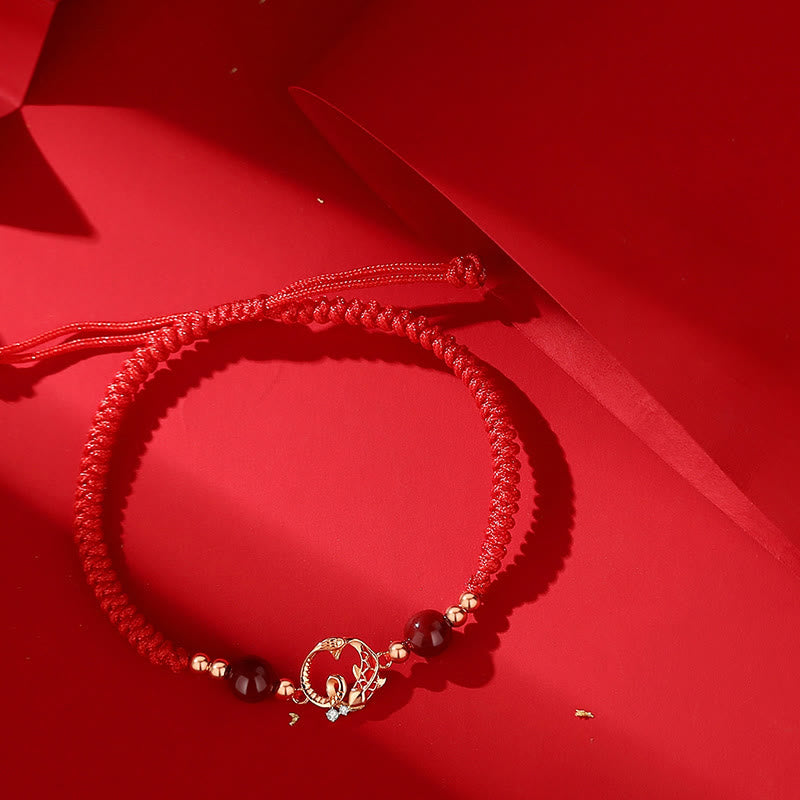 Silver Jade Cinnabar Koi Snake Bracelet – braided red cord with gold lotus charm and dark beads on red fabric, protection