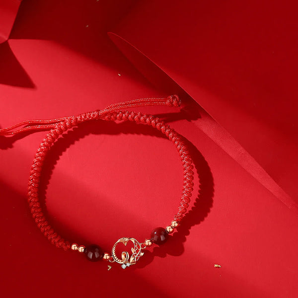 Silver Jade Cinnabar Koi Snake Bracelet – braided red cord with gold lotus charm and dark beads on red fabric, protection