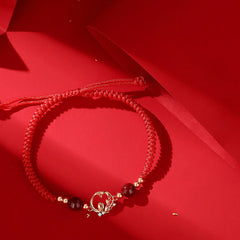 Silver Jade Cinnabar Koi Snake Bracelet – braided red cord with gold lotus charm and dark beads on red fabric, protection