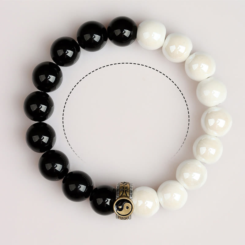 Black Obsidian White Porcelain Yin Yang Bracelet - Overhead view of yin-yang bracelet with Bagua charm detail, meditation bead bracelet