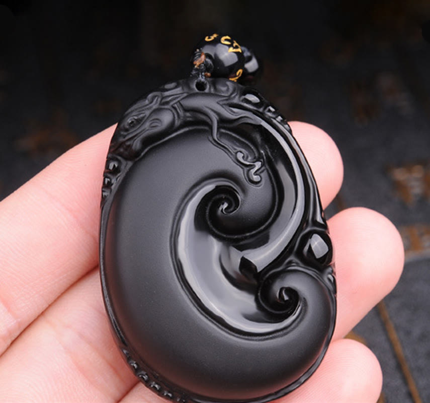 Black Obsidian PiXiu Pendant – Hand holding oval obsidian swirl carved protection pendant