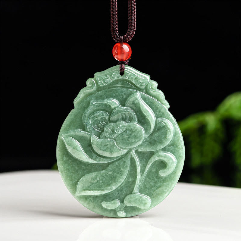 Round Lotus Jade Necklace - carved jade lotus pendant with red bead on black surface, spiritual