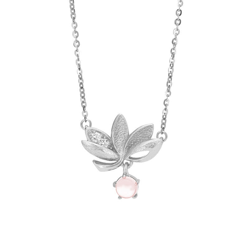 Sterling Silver Lotus Pendant Necklace - on curved white display stand with bokeh, delicate