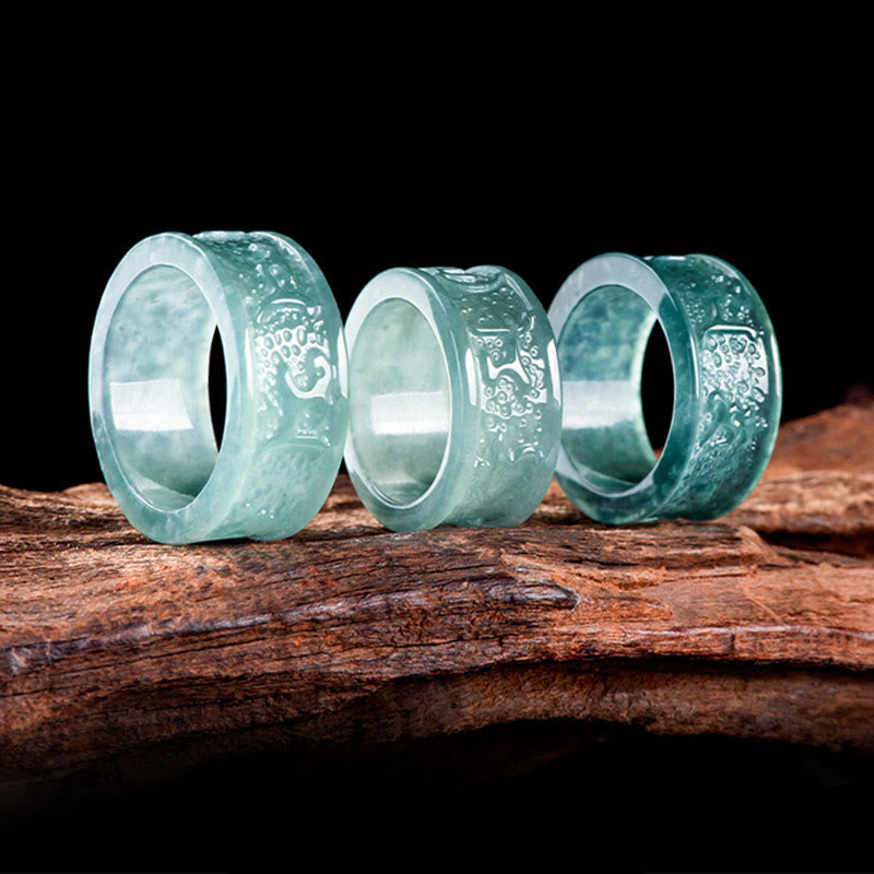 Jade Om Mani Padme Hum Ring – Three rings arranged on dark wood, carved jade set